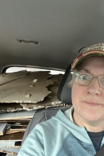 Melissa loading demolition debris into her car while renovating her Vermont cottage on a single income.