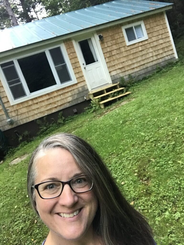 Melissa standing in front of her small Vermont cottage during an early visit after her offer was accepted.