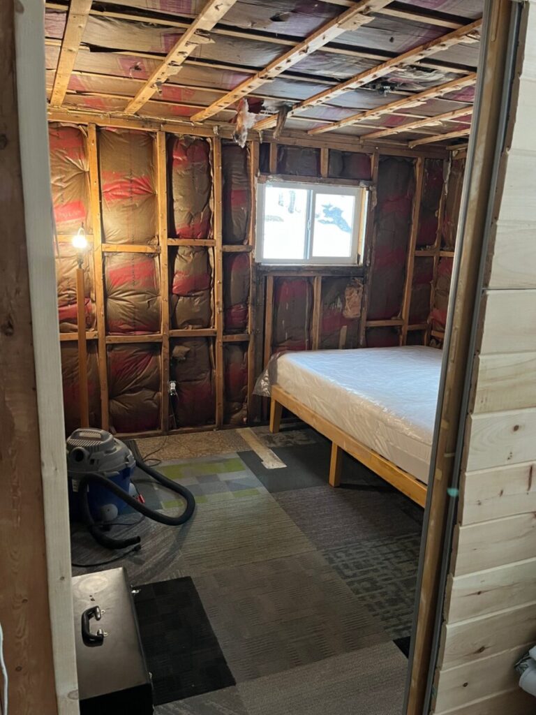 Vermont Cottage bedroom drywall and paneling removed. Insullation exposed. 